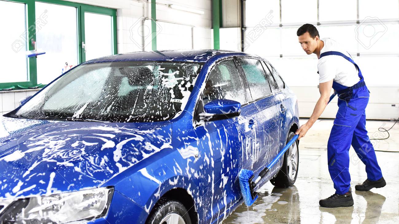 Car wash - employees of a car dealership clean a vehicle professionally